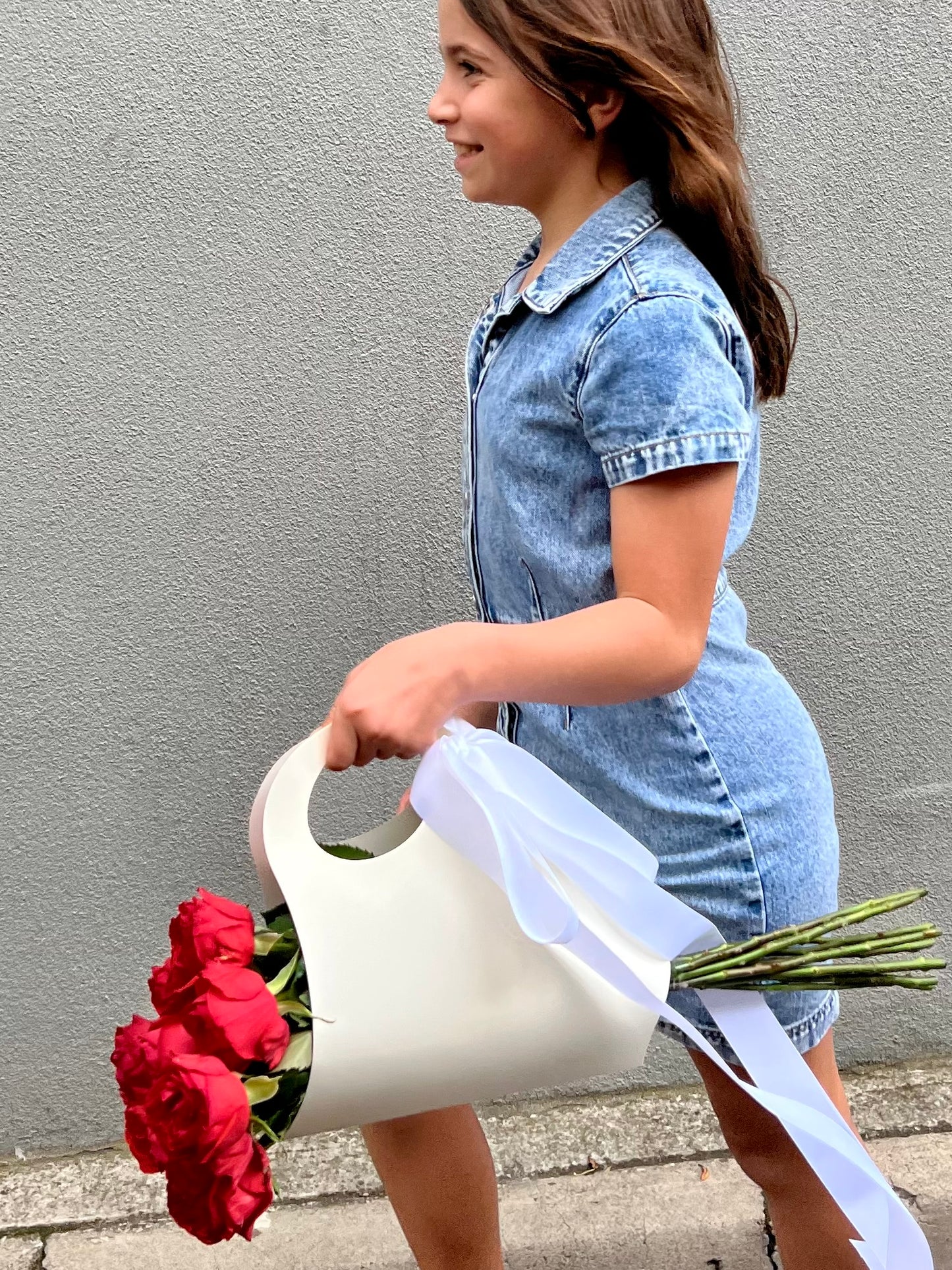 A bunch of roses in a ribboned gift bag