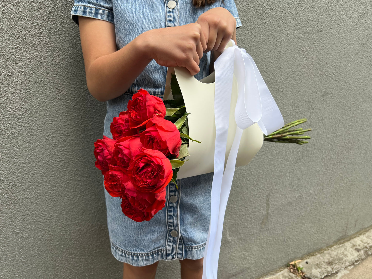 A bunch of roses in a ribboned gift bag