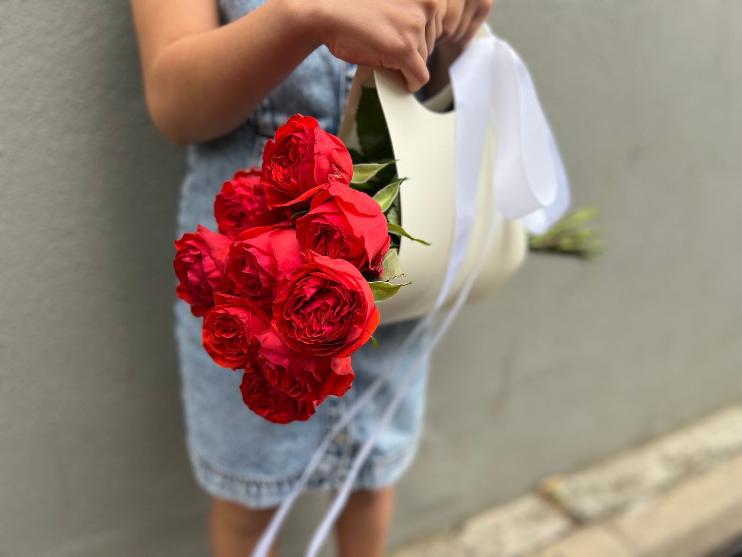 A bunch of roses in a ribboned gift bag